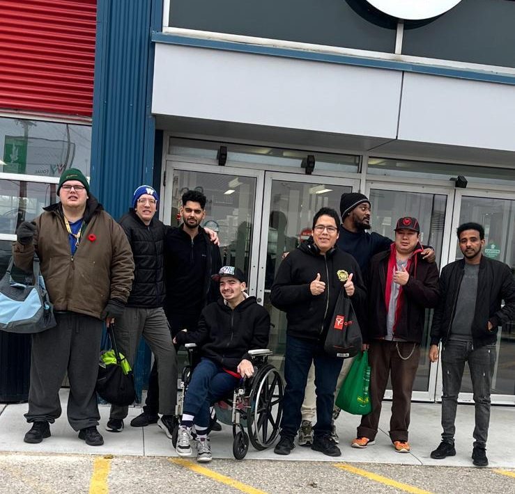 Eight participants outside the YMCA with their gym bags, heading in for a swim
